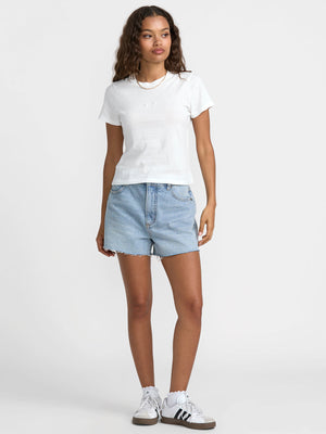 Woman wearing a white t-shirt and light blue denim shorts on a white background